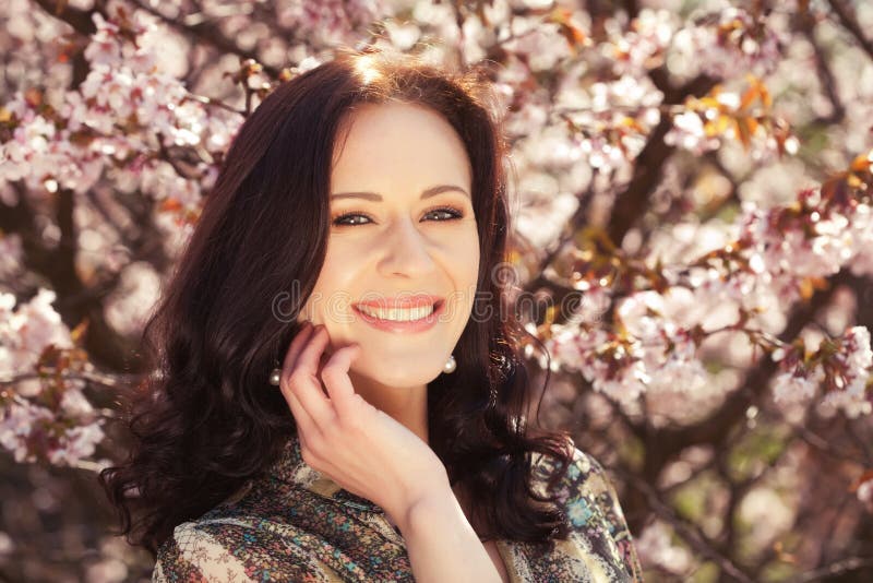 Portr?t einer sch?nen jungen Frau auf einem Hintergrund von rosa Kirschbl?ten im Fr?hjahr lizenzfreie stockfotos Portr?t einer sch?nen jungen Frau auf einem Hintergrund von rosa Kirschbl?ten im Fr?hjahr lizenzfreie stockfotos