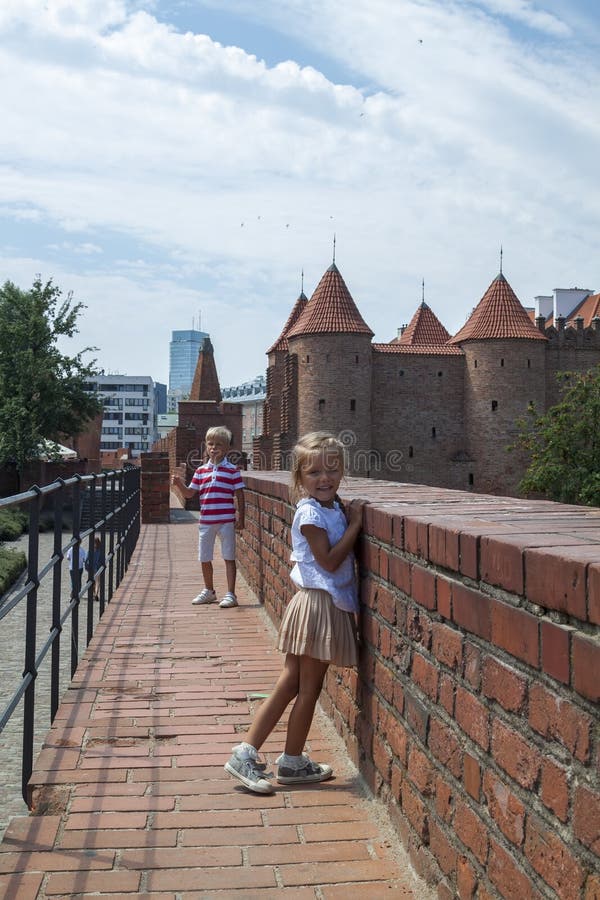 Portr?t im Freien des jungen sch?nen Jungen und des M?dchens, die auf alter Stra?e aufwirft Altes Warschau, Polen, Sommer stockfotografie Portr?t im Freien des jungen sch?nen Jungen und des M?dchens, die auf alter Stra?e aufwirft Altes Warschau, Polen, Sommer stockfotografie
