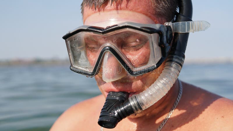 Portrain of man in mask for underwater swimming standing on sea background stock images Portrain of man in mask for underwater swimming standing on sea background stock images
