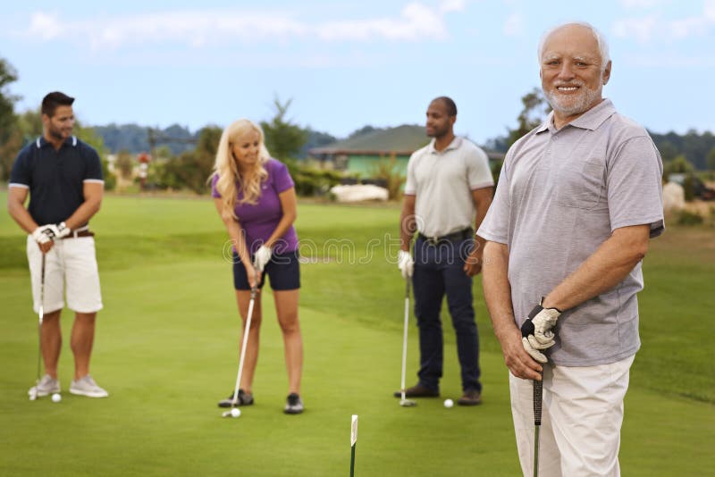 Portrait of active happy senior on the golf course, people playing at the background. Portrait of active happy senior on the golf course, people playing at the background.