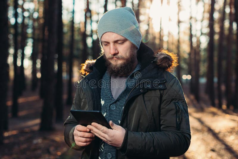 Portrait of adult man walking in the pine forest with digital tablet. royalty free stock photography Portrait of adult man walking in the pine forest with digital tablet. royalty free stock photography