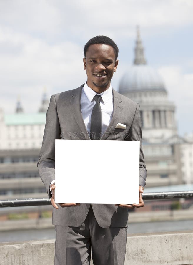 Portrait of African American businessman smiling and holding blank cardboard