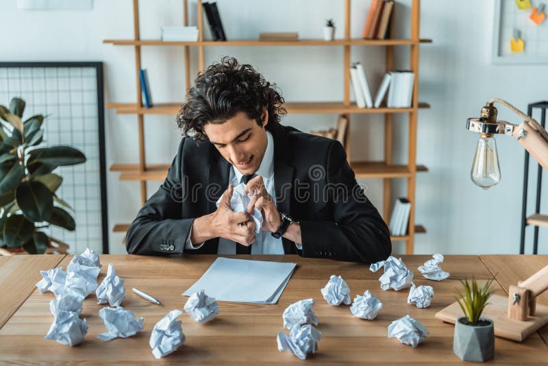 portrait of angry businessman crumpling papers at workplace stock photo portrait of angry businessman crumpling papers at workplace stock photo