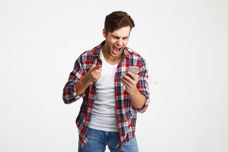 Portrait of an angry unsatisfied man looking at mobile phone royalty free stock image Portrait of an angry unsatisfied man looking at mobile phone royalty free stock image