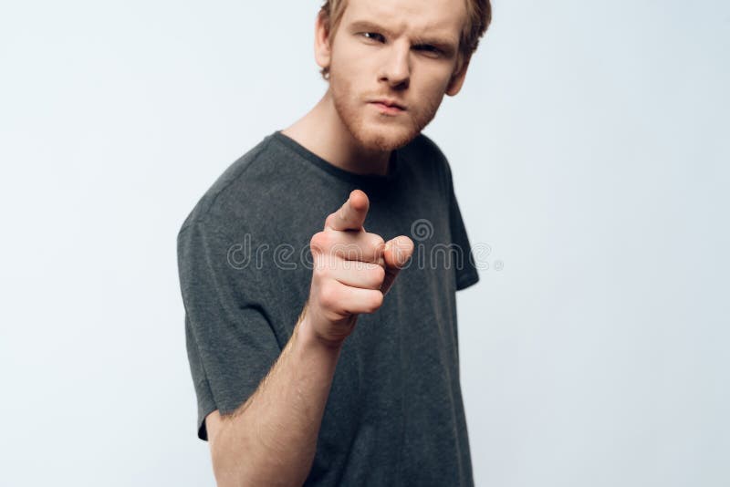 Portrait of Angry Young Man Pointing Forefinger. Ginger Serious Young Guy in Casual Clothes has Imperative Face Expression Isolated on White background royalty free stock photo Portrait of Angry Young Man Pointing Forefinger. Ginger Serious Young Guy in Casual Clothes has Imperative Face Expression Isolated on White background royalty free stock photo