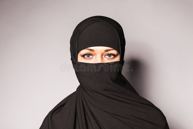 Portrait of an arabic young woman with her beautiful blue eyes in traditional islamic cloth niqab.
