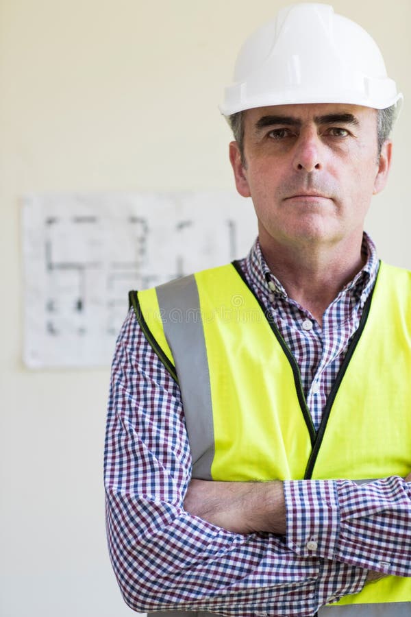 Portrait Of Architect Wearing Hard Hat With Plans In Background