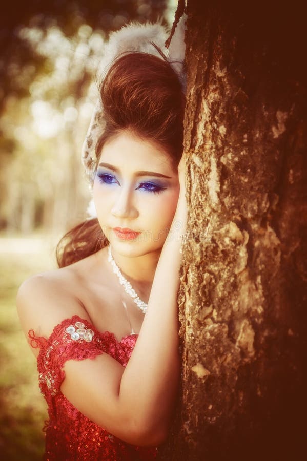 Portrait Of Beautiful Young Woman Of Red Dress Posing In Forest Stock