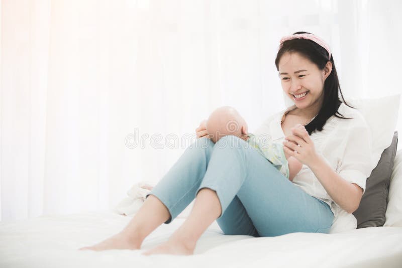 Asian beautiful mom playing with her baby.