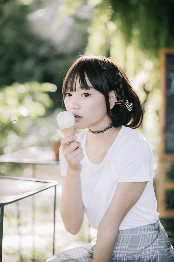 Portrait of asian girl with white shirt with ice cream vintage film style.