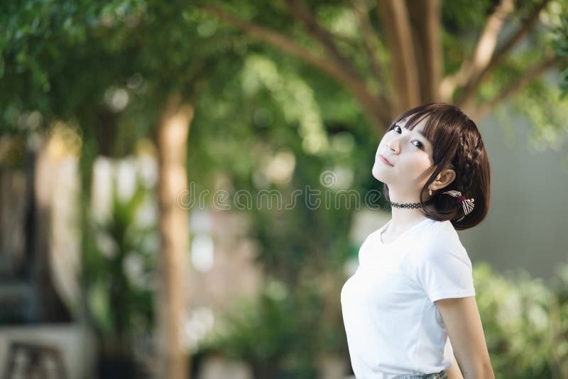 Portrait of asian girl with white shirt looking in outdoor nature vintage film style.