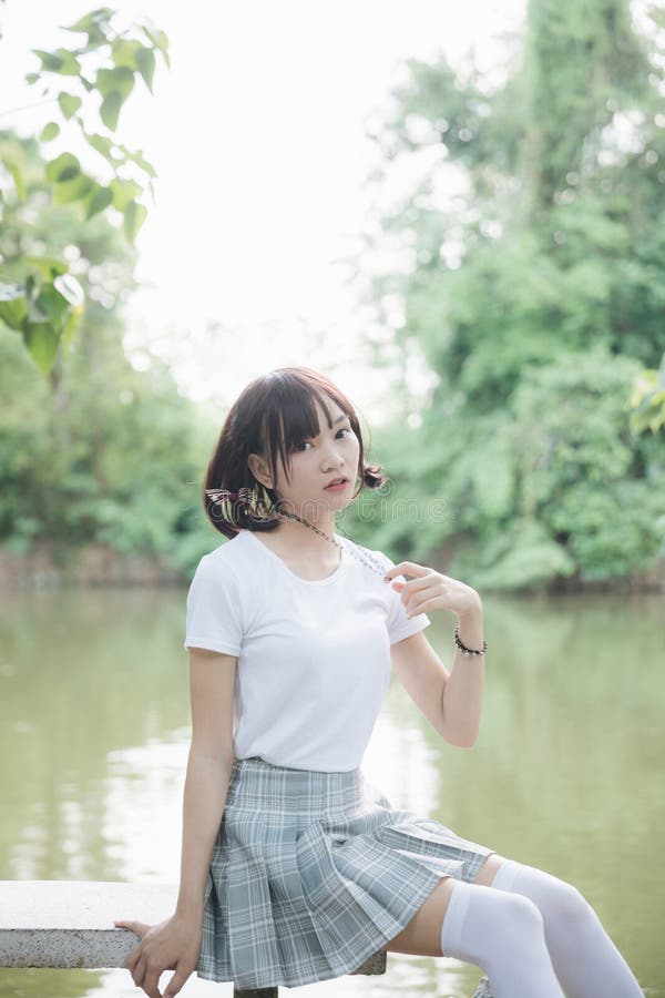 Portrait Of Asian Girl With White Shirt And Skirt Looking In Outdoor Nature Vintage Film Style