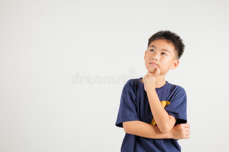 Portrait of an Asian kid boy deep in thought, standing with chin in hand stock photo