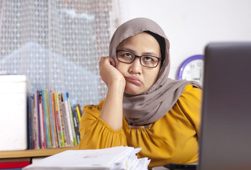 Portrait of Asian muslim businesswoman looking tired sleepy and lazy waiting for something in front of her laptop at the office indonesian malaysian arab worker head bored lady desk job desktop hands annoyed exhausted computer employee overworked workload enough trouble stress technology people pensive networking expressing boredom corporate desperation weakness female angry asleep frustrated desperate hold failed unsuccessful life failure overload. Portrait of Asian muslim businesswoman looking tired sleepy and lazy waiting for something in front of her laptop at the office indonesian malaysian arab worker head bored lady desk job desktop hands annoyed exhausted computer employee overworked workload enough trouble stress technology people pensive networking expressing boredom corporate desperation weakness female angry asleep frustrated desperate hold failed unsuccessful life failure overload