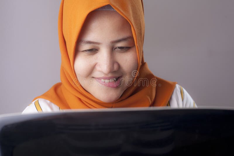 Woman with Naughty Expression Looking at Laptop Stock Photo