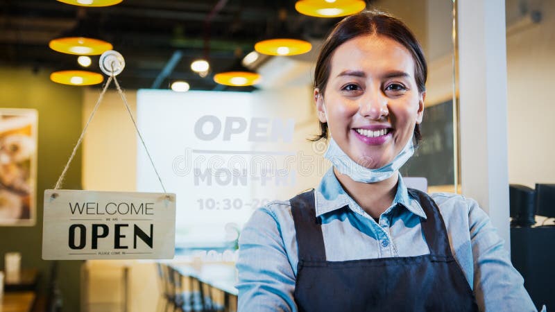 Portrait of Asian woman restaurant or coffee shop owner smile, hanging open sign post. Small business entrepreneur royalty free stock image