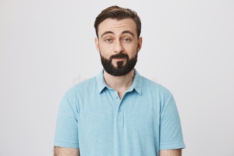 Portrait of attractive adult with beard and moustache expressing that he is not impressed, lifting his eyebrows and