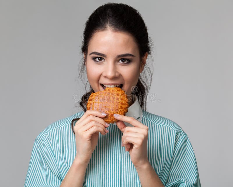 Portrait of an Attractive Biting a Biscuit Stock Photo Image