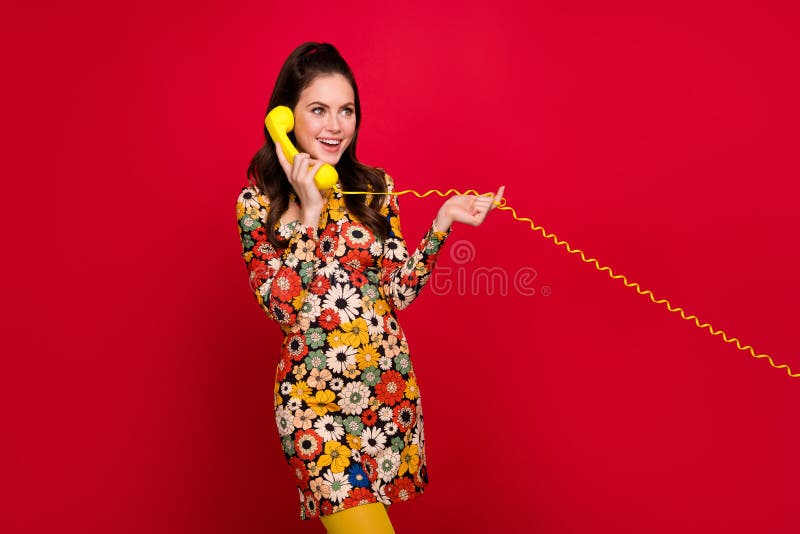 Portrait of attractive cheerful girly girl talking on phone land line operator isolated over bright red color background