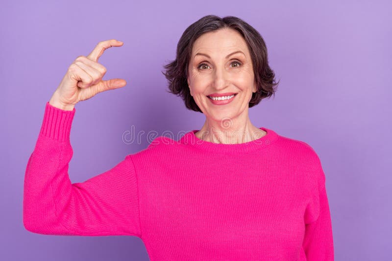 Portrait Of Attractive Cheerful Mature Woman Showing Small Size Object Isolated Over Violet