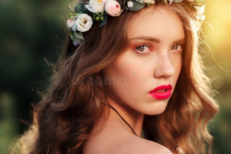 Portrait of attractive girl in wreath at sunset