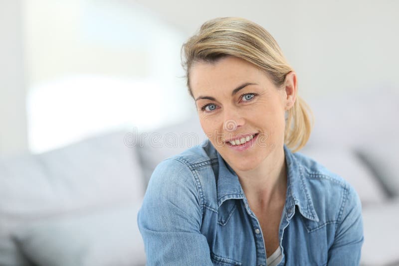 Portrait of attractive mature woman sitting at home