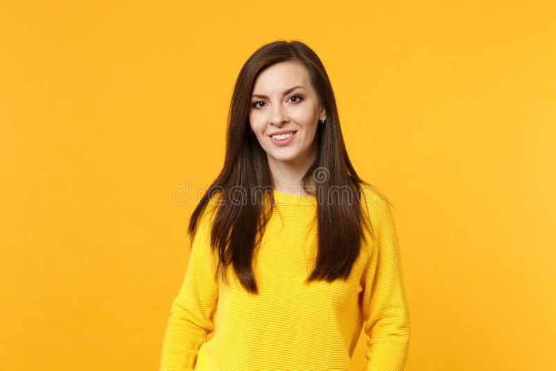 Portrait of attractive smiling young woman in casual clothes looking camera isolated on bright yellow orange wall royalty free stock images Portrait of attractive smiling young woman in casual clothes looking camera isolated on bright yellow orange wall royalty free stock images