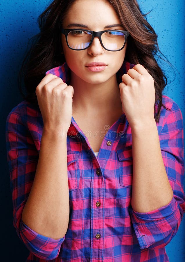 Portrait attractive woman in glasses on blue background.