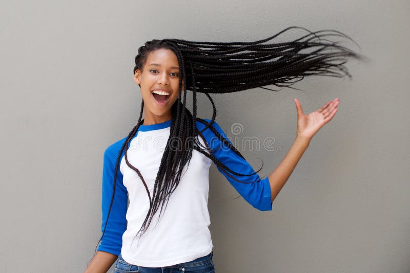 Attractive young african american woman with long braided hair on gray background