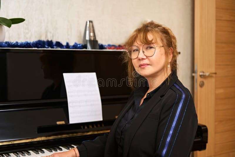 Portrait authentique d'asiatique mature professeur de piano en vêtements décontractés et lunettes regarder en toute confiance la c image libre de droits