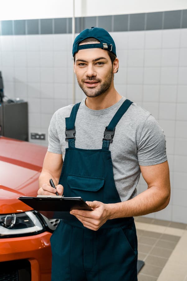 Portrait of Auto Mechanic with Notepad Looking at Camera Stock Photo