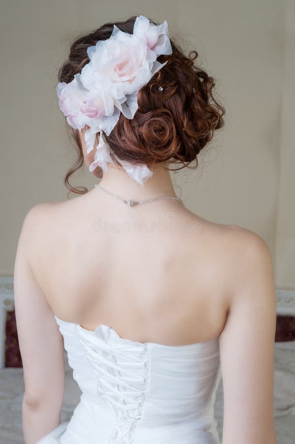 Portrait of back of bride in white dress with hair style and flo