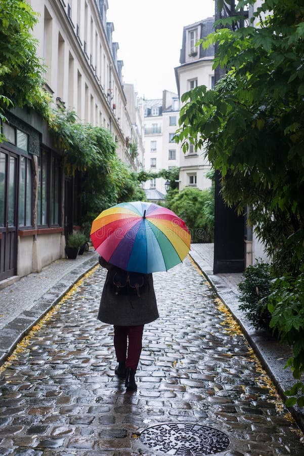 Porträt auf der frauen straßen Regenbogen ein Regenschirm.