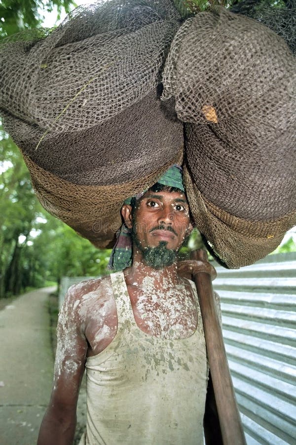 Portrait of Bangladeshi fisherman lugging fishnet
