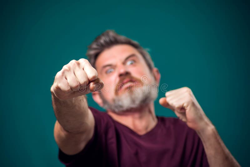 A Portrait Of Bearded Angry Man Showing Fist At Camera People And