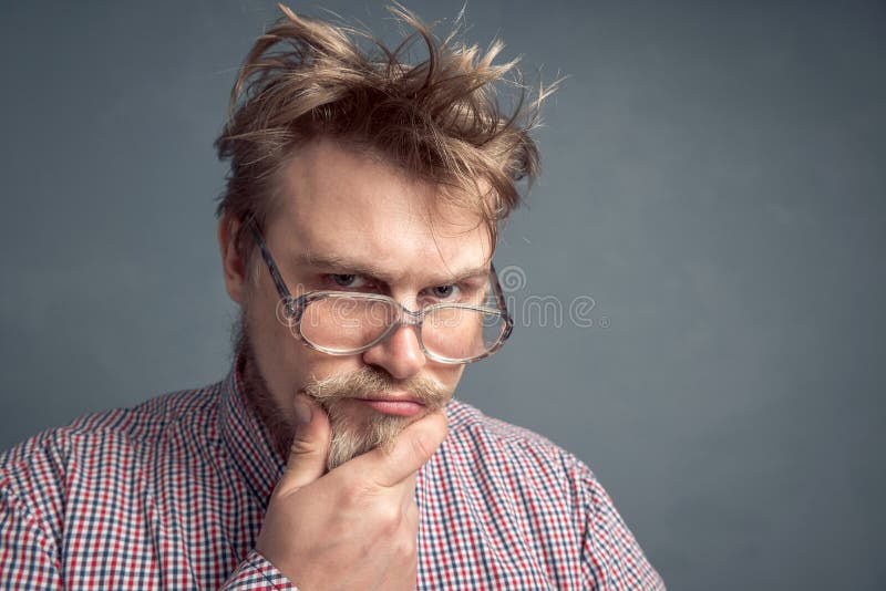 Portrait of a Bearded Nerd with a Disheveled Hairstyle, with a Thoughtful  Look Looking through His Large Glasses Stock Image - Image of  brainstorming, ideas: 182089769
