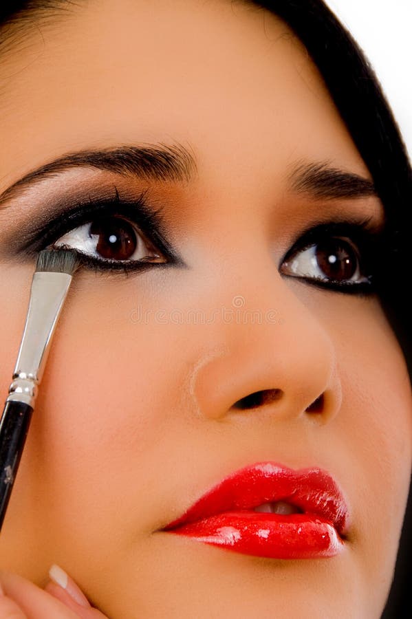 Portrait of beautician doing eye make up of woman