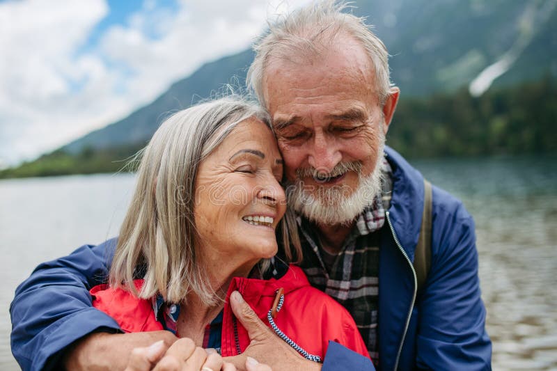 Portrait of beautiful active senior couple hiking together in autumn mountains.