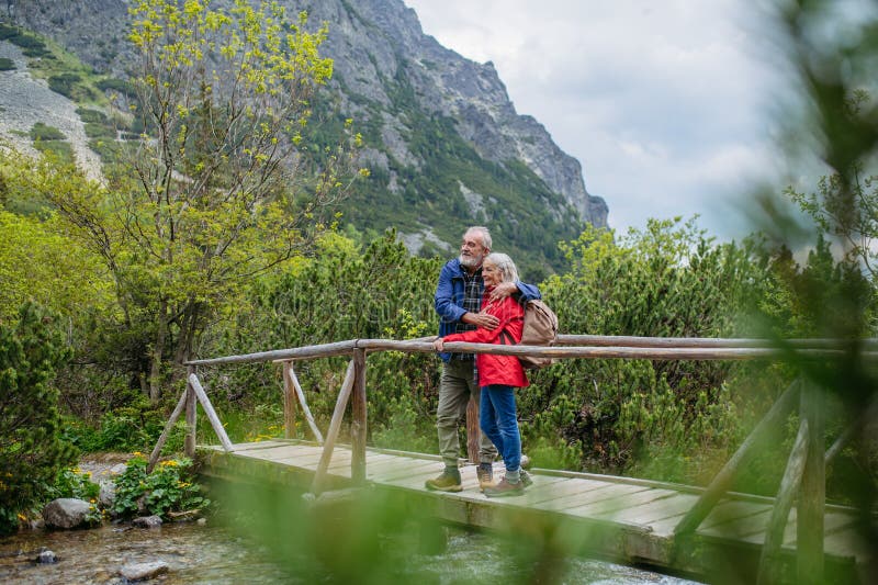 Portrét krásneho aktívneho staršieho páru turistiky spolu v jesenných horách.