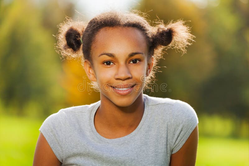 Portrait of beautiful African girl sitting in park