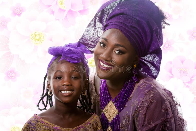 Portrait of beautiful African lady and little girl in traditional dress. Portrait of closeup beautiful African lady and little girl in traditional purple stock photo Portrait of beautiful African lady and little girl in traditional dress. Portrait of closeup beautiful African lady and little girl in traditional purple stock photo
