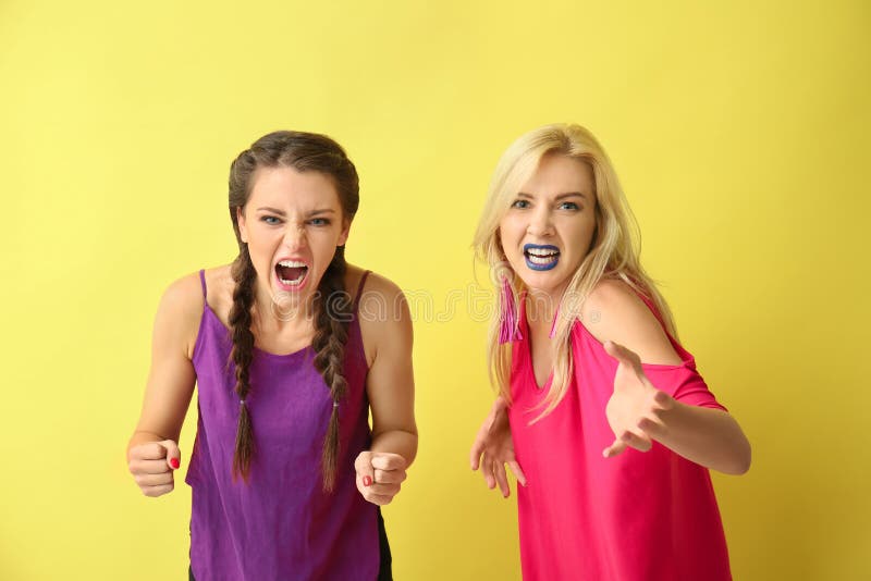 Portrait of beautiful aggressive women on color background