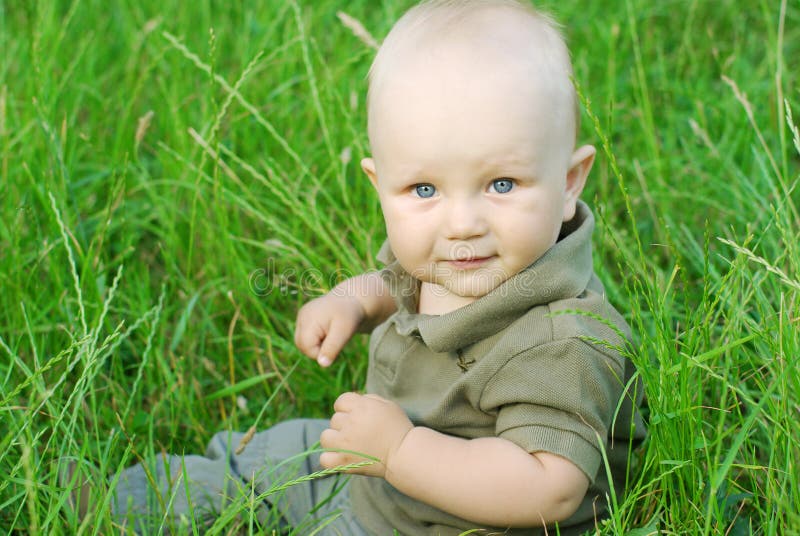 Portrait of beautiful baby boy on a grass