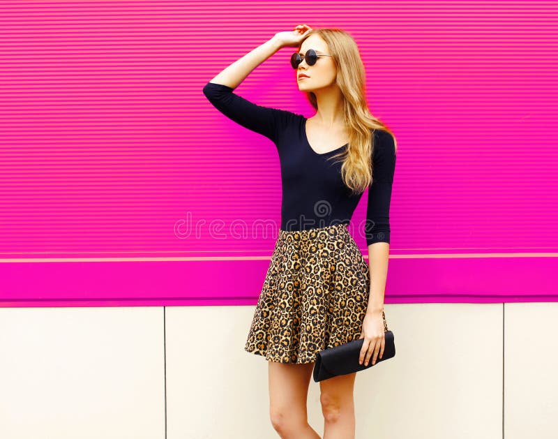 Portrait beautiful blonde woman model posing in leopard skirt, sunglasses with handbag clutch stock photos Portrait beautiful blonde woman model posing in leopard skirt, sunglasses with handbag clutch stock photos