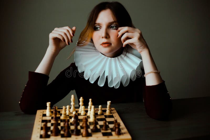 Woman Hand Holding a White Queen Piece Over a Chess Board