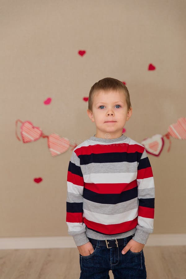 Portrait of a beautiful boy in a striped sweater and jeans.