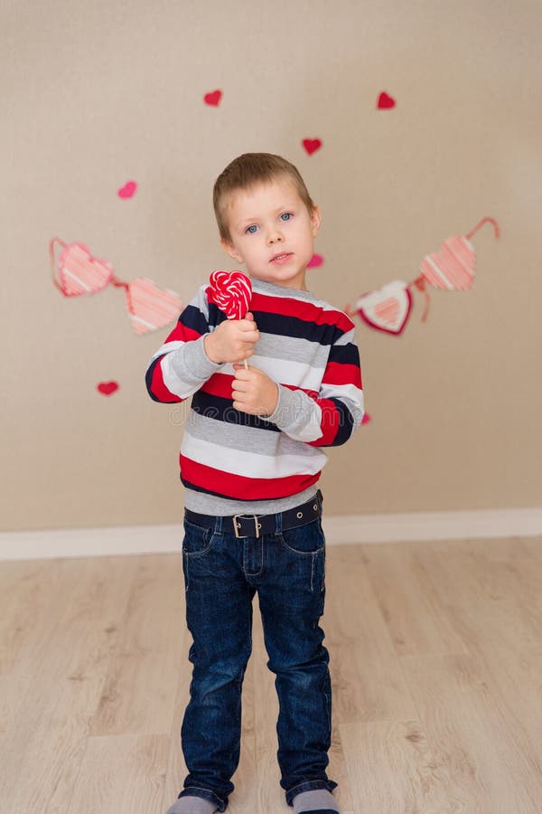 Portrait of a beautiful boy in a striped sweater and jeans.