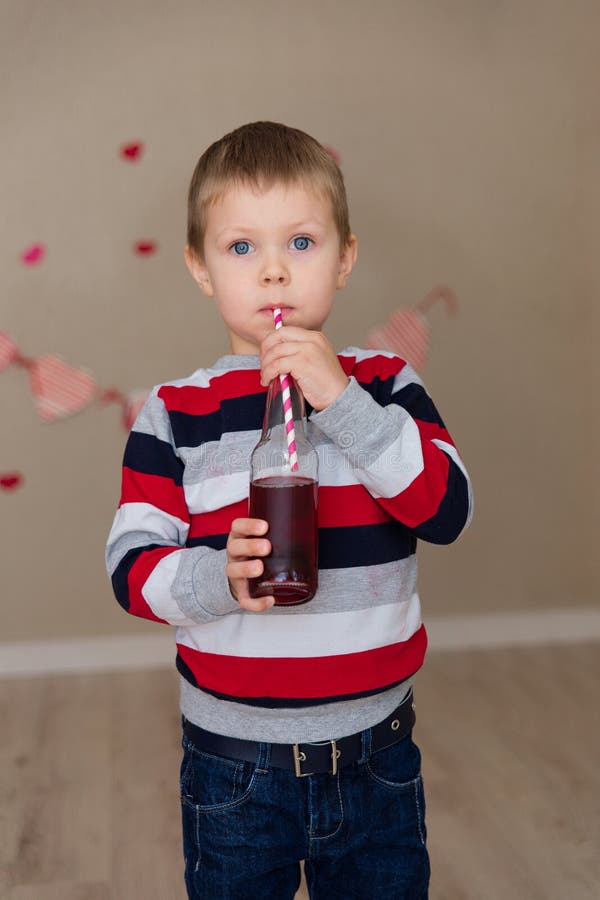 Portrait of a beautiful boy in a striped sweater and jeans.