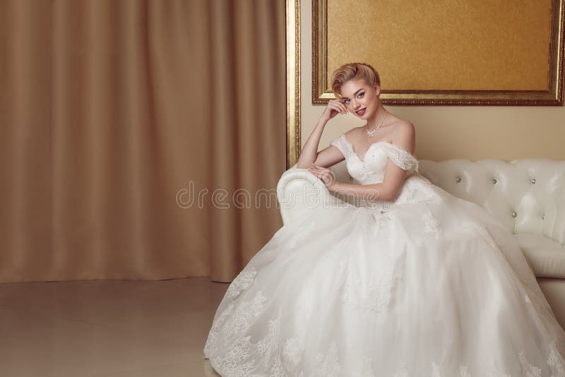 Portrait of beautiful cheerful bride in white dress. Classic sty