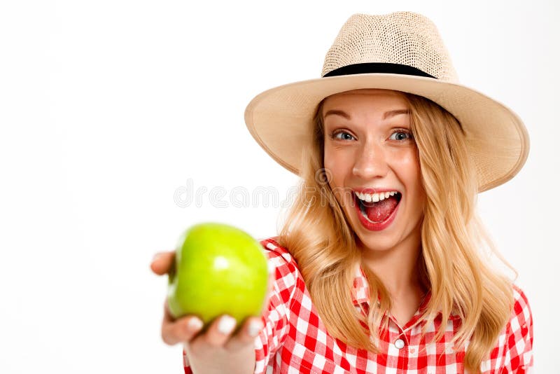 Portrait of beautiful country girl with apple over white background.